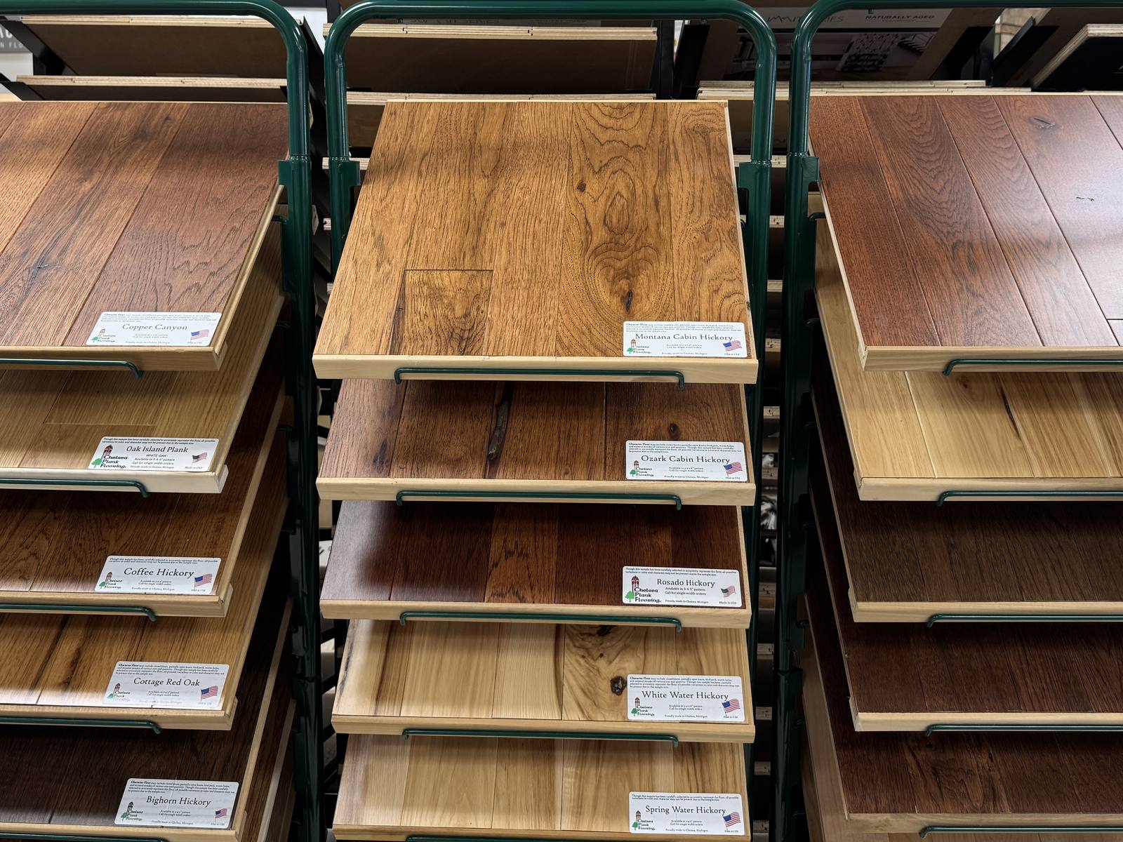 Chelsea Plank Flooring sample racks in the A & A showroom, with hickory and oak boards like Copper Canyon, Montana Cabin Hickory, and Rosado Hickory