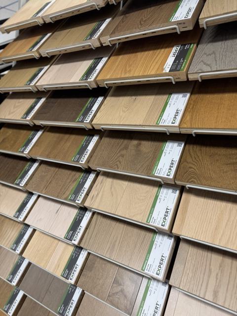 A rack of Expert Hardwood Floors by Lauzon samples in red oak and hard maple, from the Essential, Decor, and Lodge series